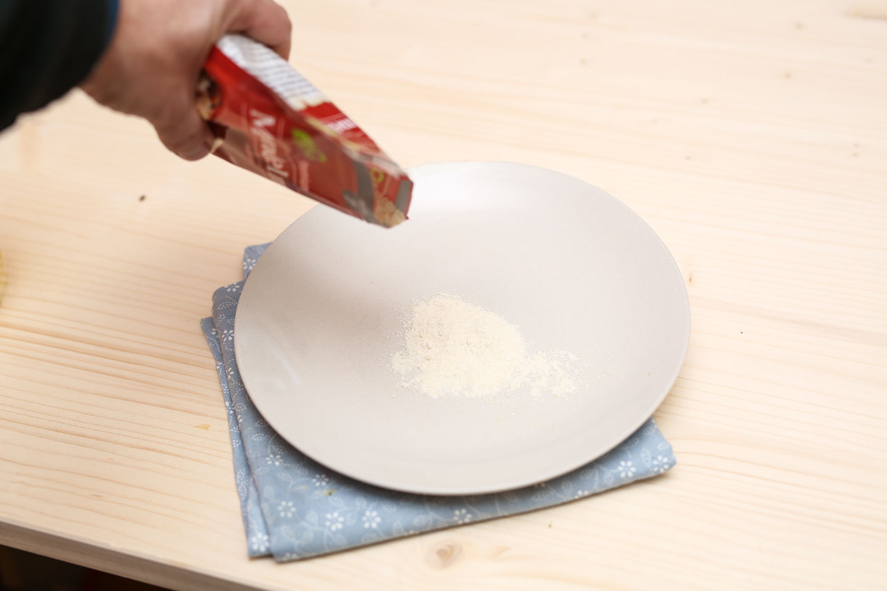 Fülle einen Teller mit Mandelmehlpulver aus