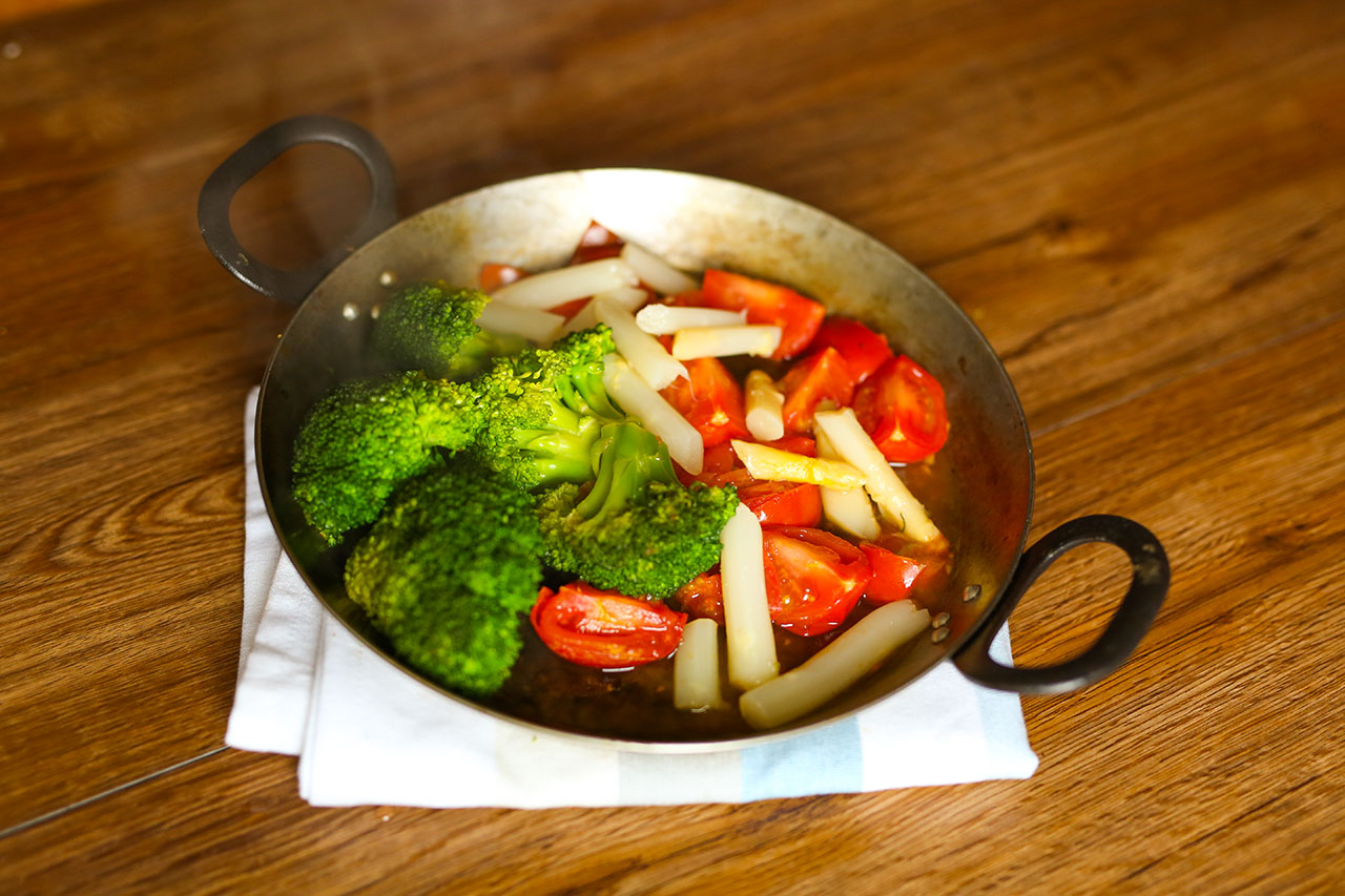 Nach dem das Fleisch fertig gebraten wurde nimmst du es aus der Pfanne.
Brate eine Knoblauchzehe an.
Dann füllst du etwas Wasser hin (ca 200ml) und gibst den Brokkoli, Spargel und Tomaten hinzu. Lass alles ca. 6 Minuten garen.
