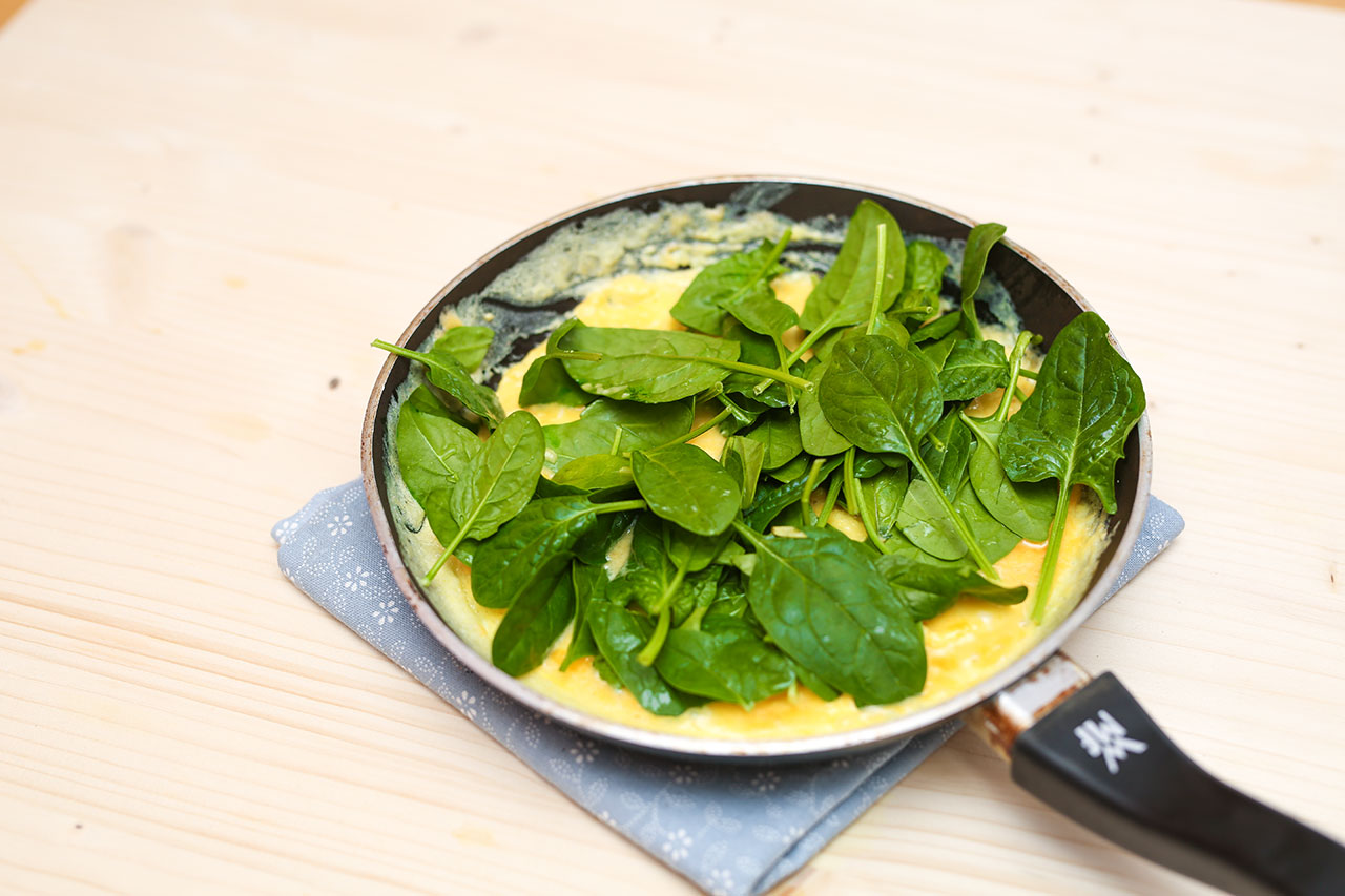 Streue den Blattspinat auf das fast fertige Omlette und lass sie 2 Minuten ziehen. Dann klappst du das Omelette zusammen und servierst es zusammen mit dem Joghurt.